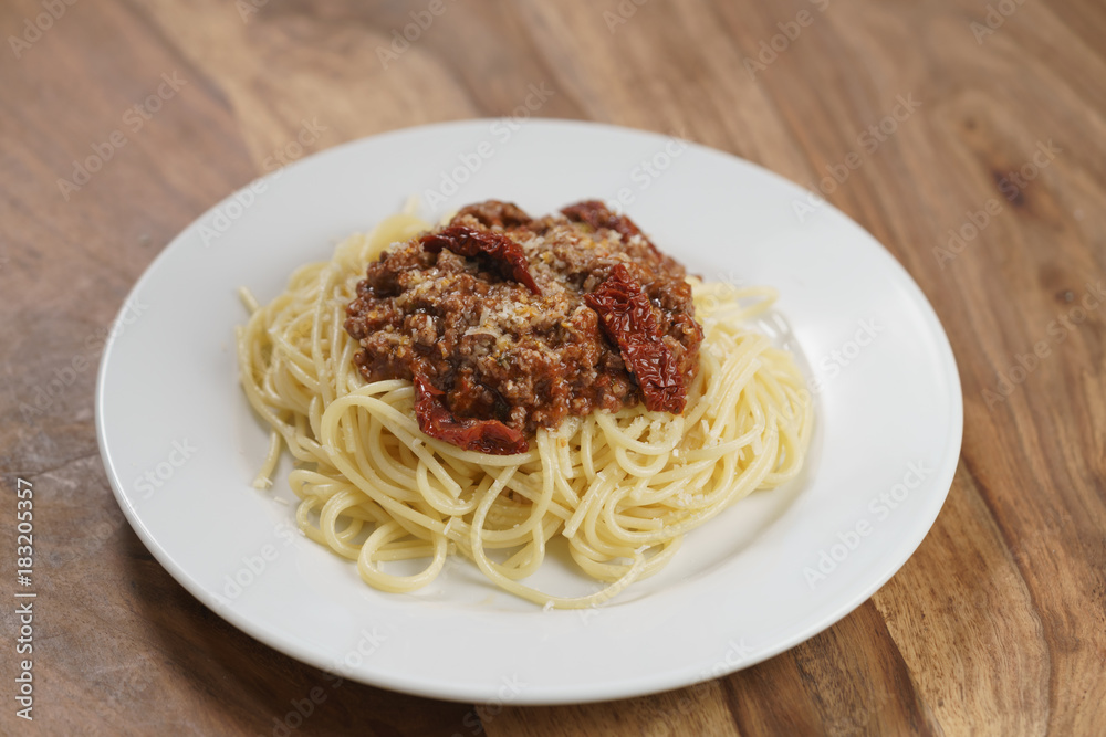 spaghetti bolognese on white plate on wood table spaghetti bolognese on white plate on wood table