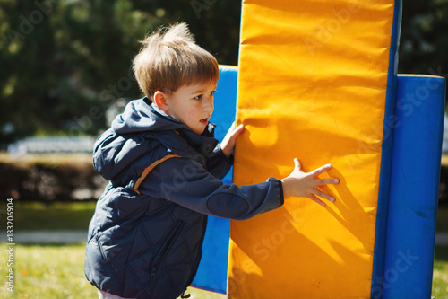 a child plays in the Park,builds a house out of large cubes photo