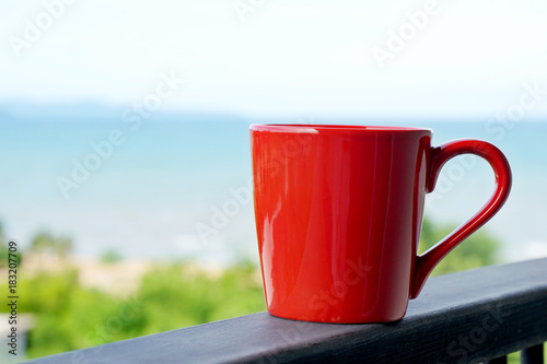 Red coffee mug relax in the morning with sea view background
