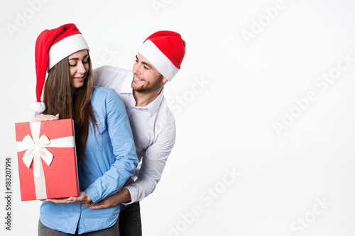 Man and woman smiling and holding presents on a white background.
