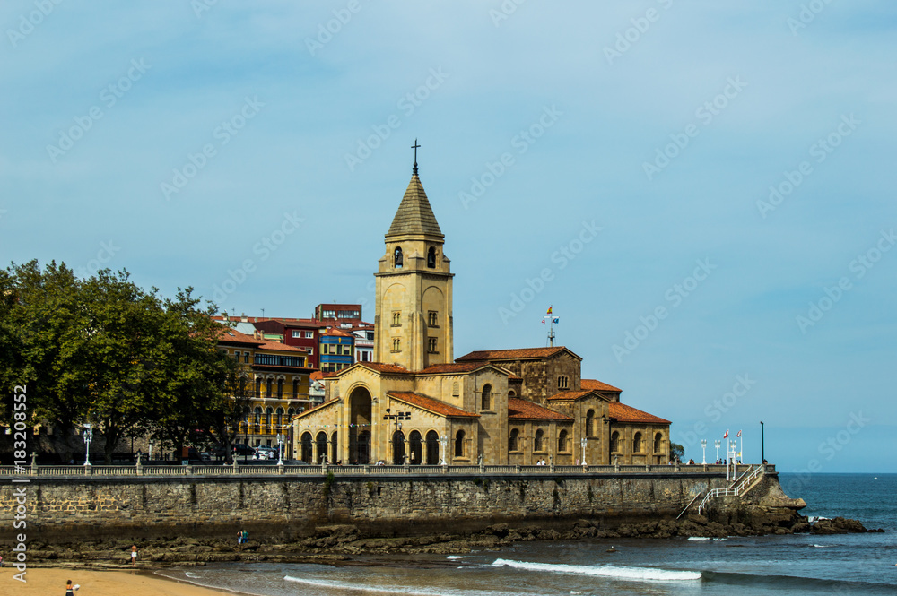 Landscape of San Lorenzo beach and San Pedro church in Gijon, Asturias, Spain.