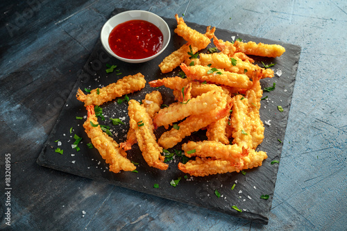 Fried Shrimps tempura with sweet chili sauce on black board stone