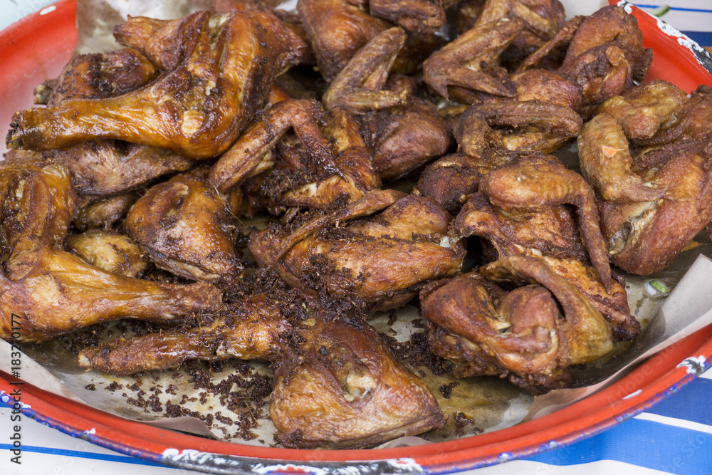 Baked chicken wings in pan on table. side view