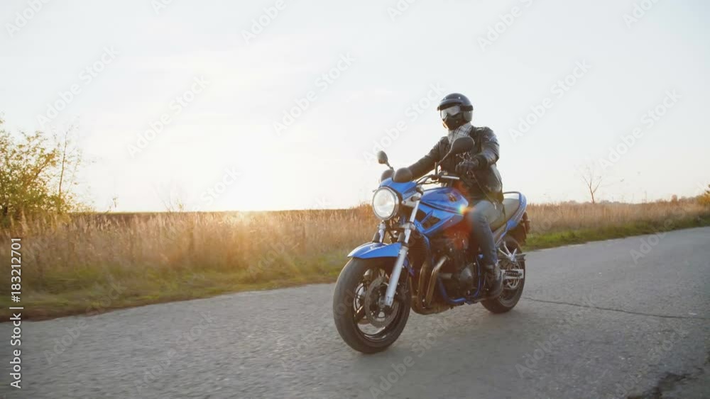 The biker riding on a motocycle on the road in sunny day. 4K The biker riding on a motocycle on the road in sunny day. 4K