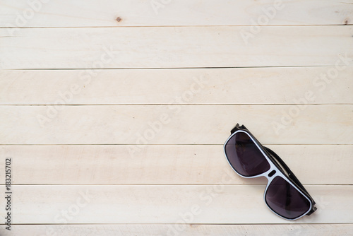 Sunglasses on light wooden table. Summer vacation concept. Place for text.