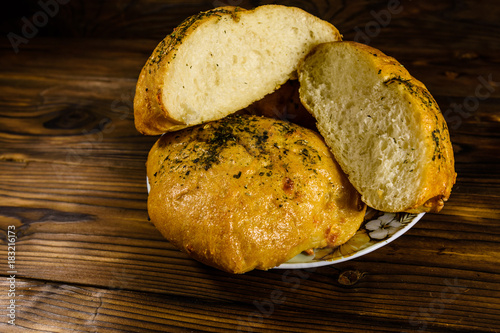 Plate with italian bun ciabatta on wooden table