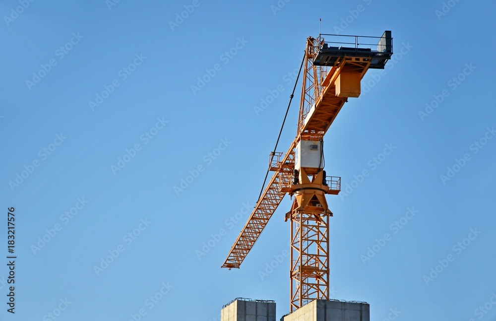 Fototapeta premium Construction cranes against a blue sky background