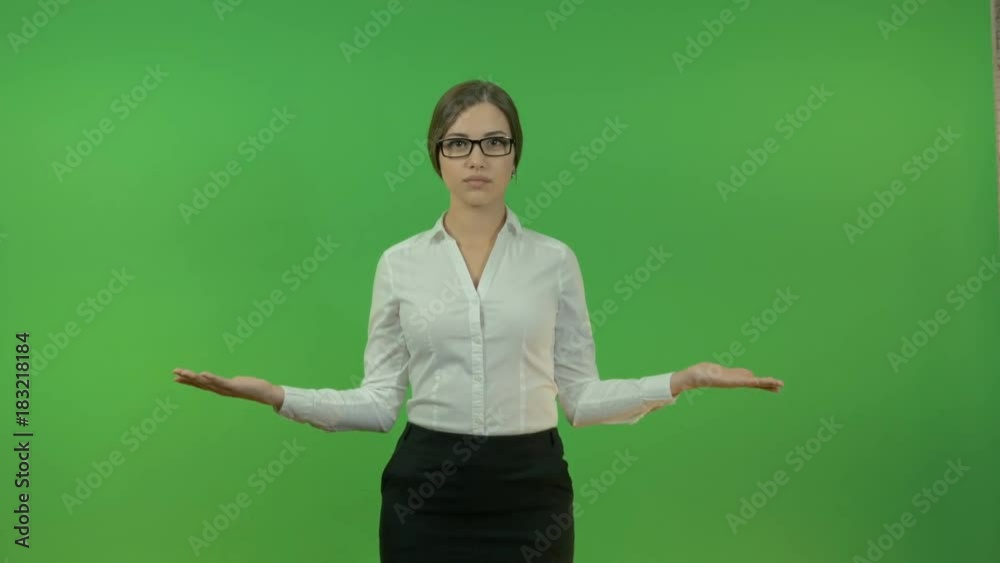 Young business woman raising her hands in different directions on a green background. Young business woman raising her hands in different directions on a green background.
