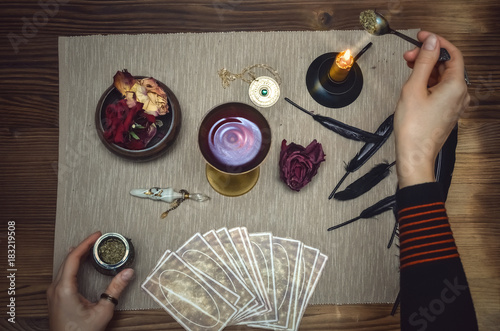 Woman witch prepare a magic potion. Future reading. Tarot cards on fortune teller desk table.