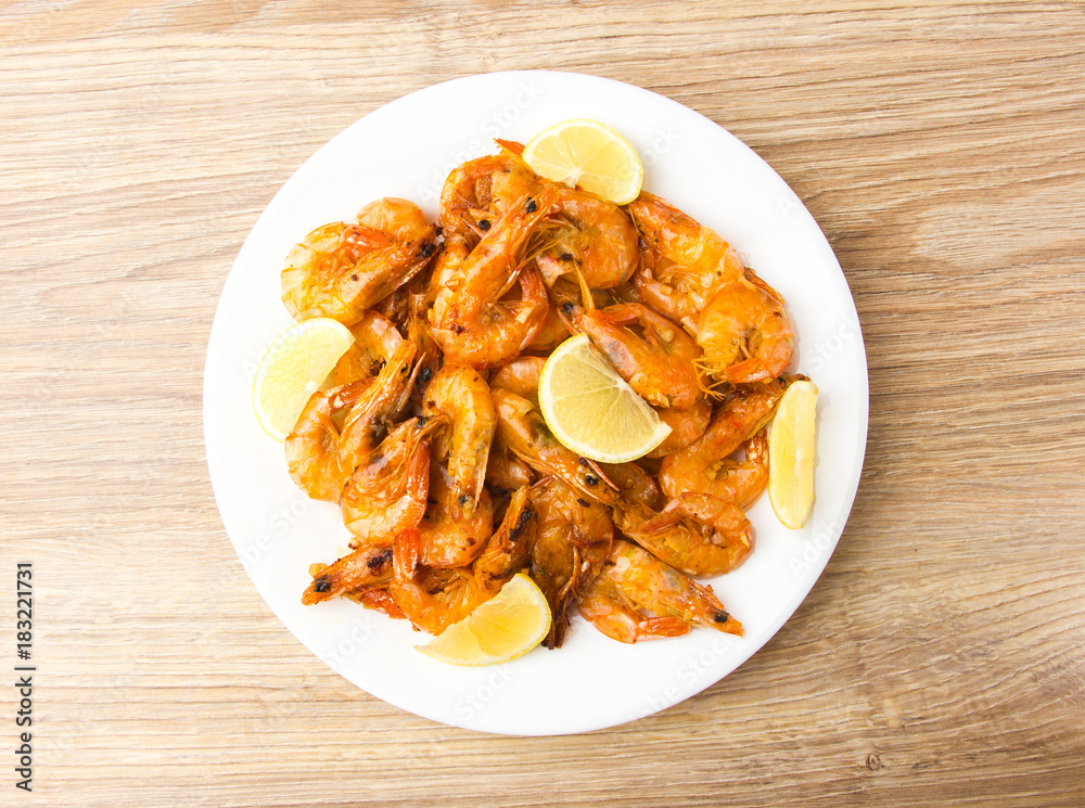 Fried shrimps with lemon. Shrimp fried in a frying pan with butter and garlic.