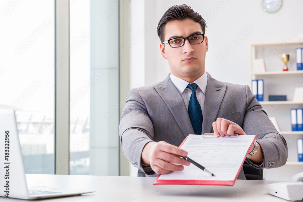 Businessman signing business documents in office