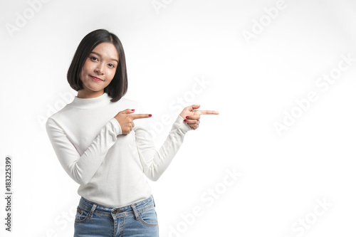 Beautiful young asian woman  pointing at whitespace