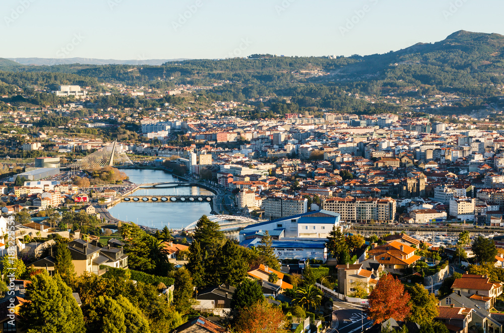 Open view of the historical city of Pontevedra from an elevated viewpoint. Bridges crossing Lerez river during sunset.