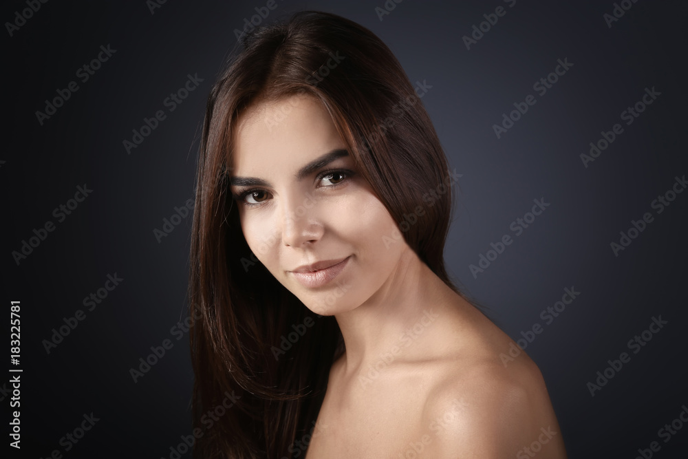 Beautiful young woman with eyelash extensions on grey background Beautiful young woman with eyelash extensions on grey background