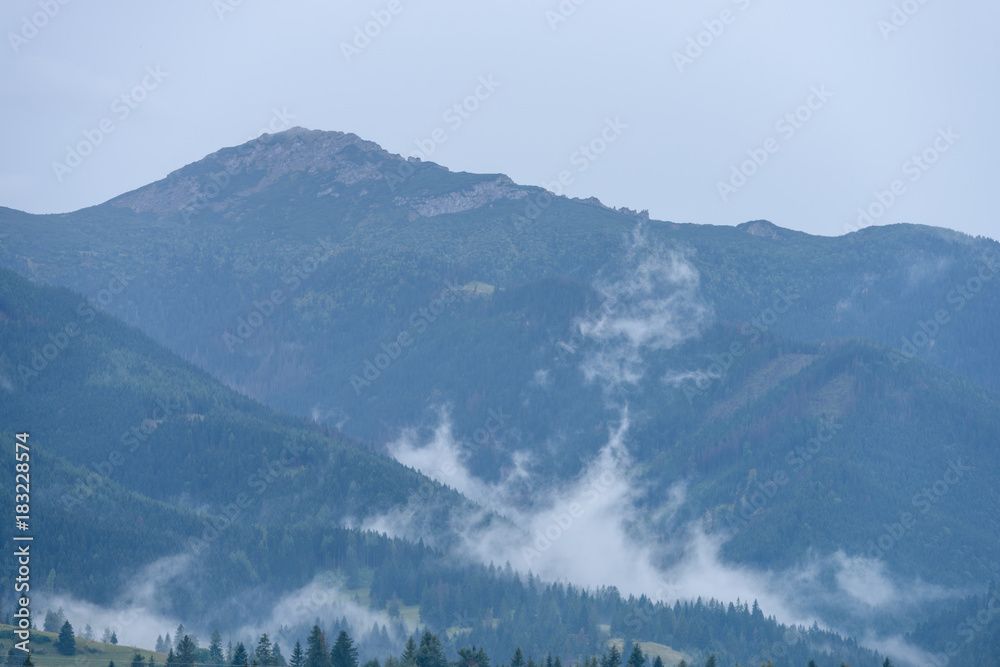 mountain tops in  autumn covered in mist or clouds