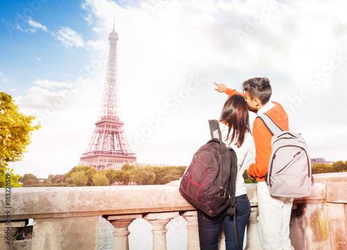 Canvas Print Young couple with backpacks walking along Paris