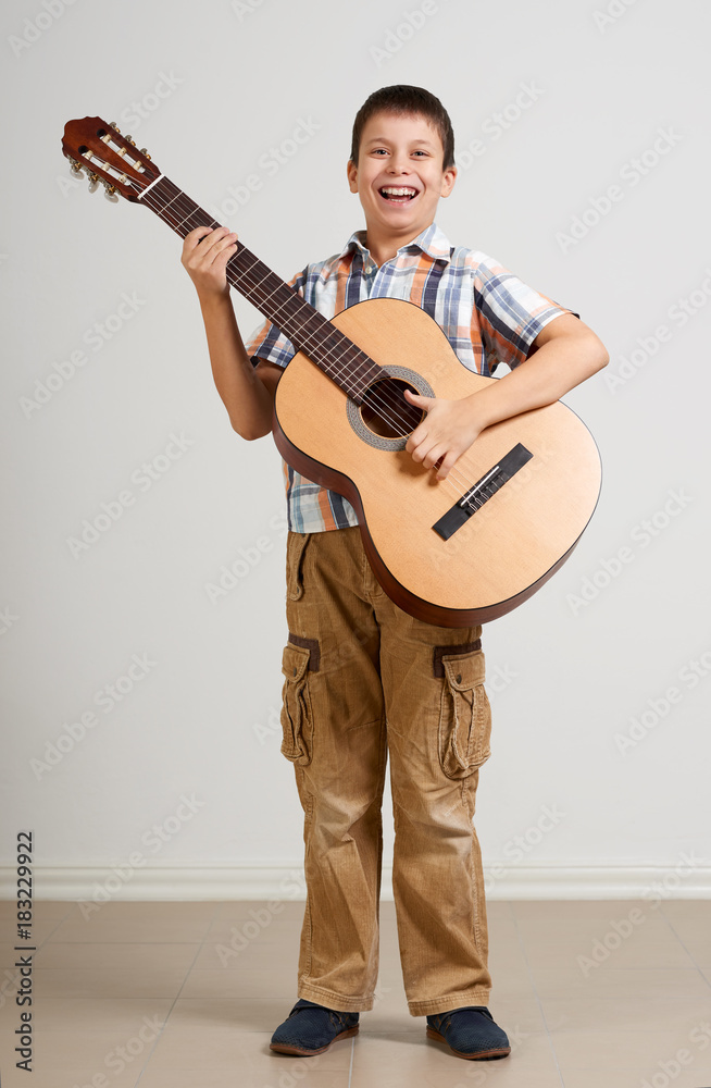 Naklejka premium Boy portrait with acoustic guitar