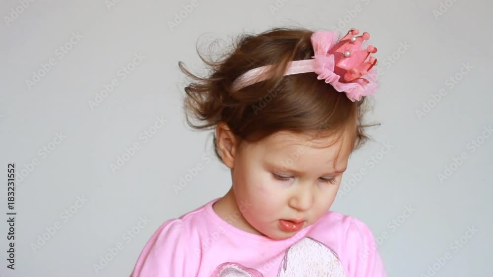 Portrait is a cute little girl who paints her lips with red lipstick. Cosmetics and makeup, powder and brush. Funny child. Fashionable Portrait is a cute little girl who paints her lips with red lipstick. Cosmetics and makeup, powder and brush. Funny child. Fashionable