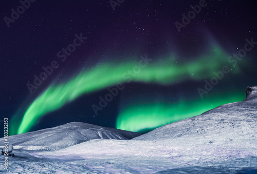 Fototapeta Naklejka Na Ścianę i Meble -  The polar arctic Northern lights aurora borealis sky star in Norway Svalbard in Longyearbyen city the moon mountains