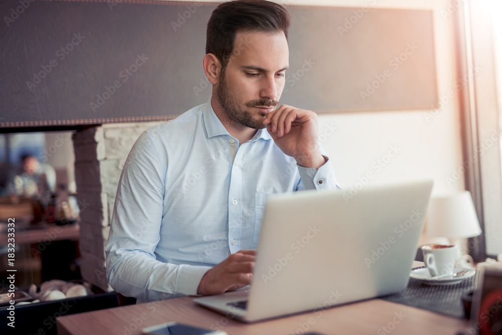 Young man working with laptop in office. Young man working with laptop in office.