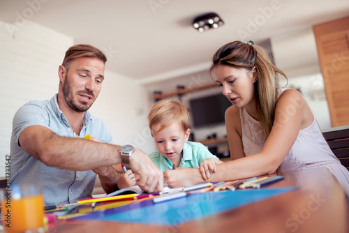 Mother and father drawing together with their child.