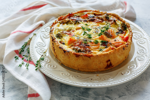 Quiche with salmon, broccoli,red pepper and thyme. photo