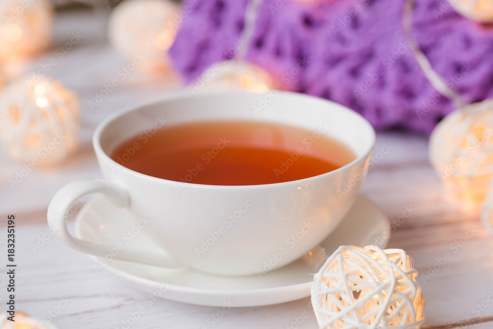 Cup of black tea, plaid, and Christmas garlands glow Cup of black tea, plaid, and Christmas garlands glow