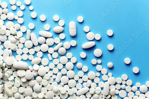White medicine pills on a blue photo