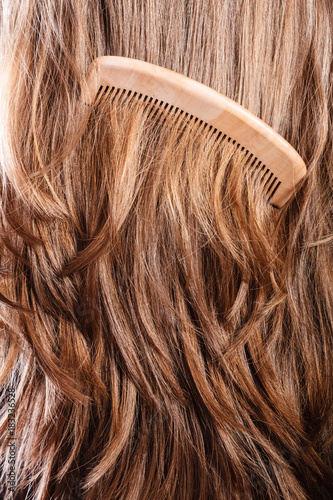 Straight brown hair with wooden comb closeup