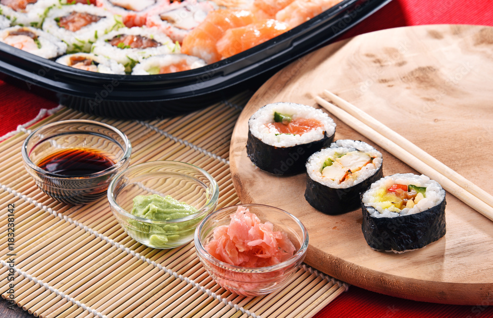 Composition with assorted sushi rolls and bowls of spices Composition with assorted sushi rolls and bowls of spices
