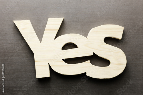 Wood word yes on a grey background