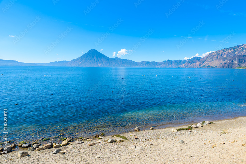 Wooden pier at Lake Atitlan on the beach in Panajachel, Guatemala.  With beautiful landscape scenery of volcanoes Toliman, Atitlan and San Pedro in the background.