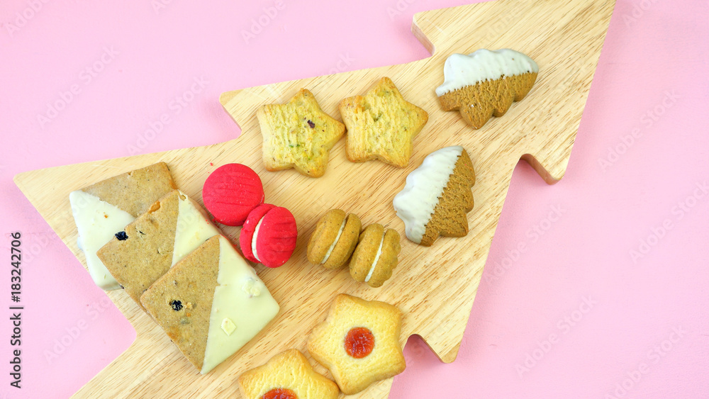 Festive collection of English style traditional Christmas holiday biscuits, cookies, and fruit mince pies, overhead on modern pink background. Festive collection of English style traditional Christmas holiday biscuits, cookies, and fruit mince pies, overhead on modern pink background.