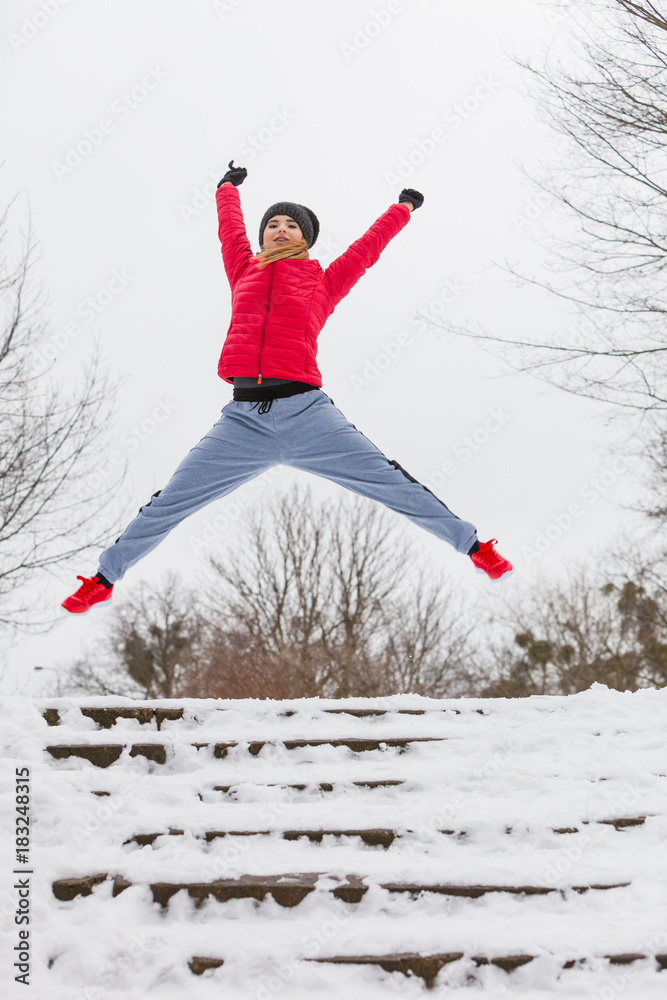Woman wearing sportswear exercising outside during winter
