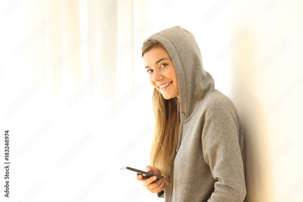 Smiley teen holding phone and looking at you Smiley teen holding phone and looking at you