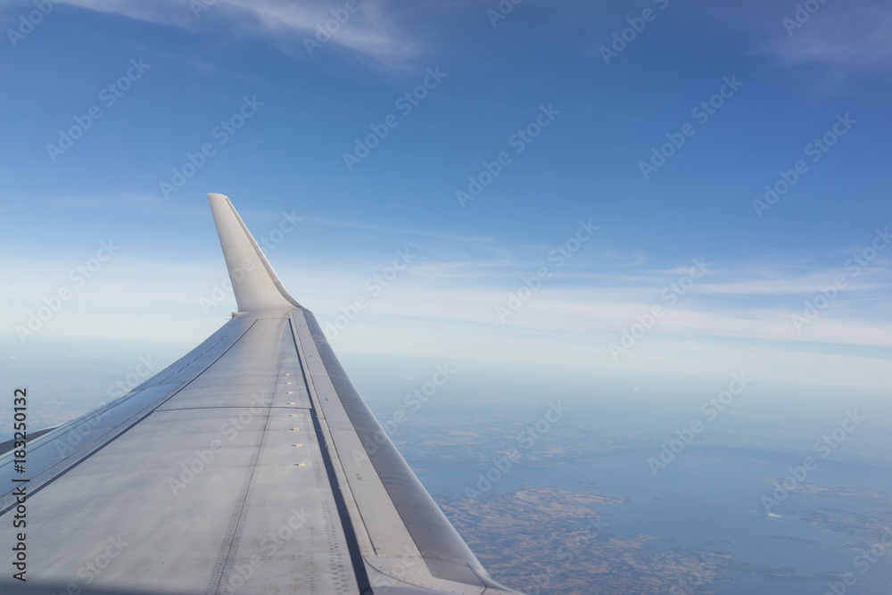 Aerial wing of airplane in bright blue sky day light using as vacation, tourism or holidays trip concept