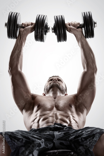 Muscular bodybuilder guy doing exercises