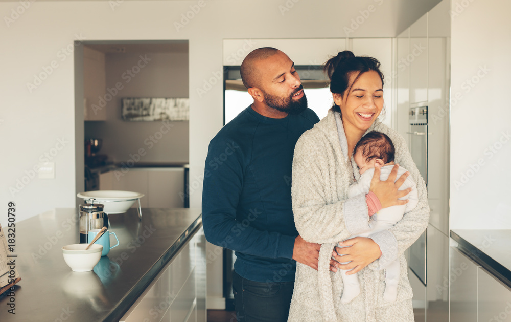 Couple with their little baby boy in kitchen Couple with their little baby boy in kitchen