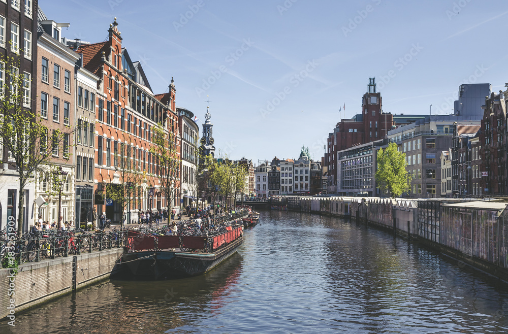 Traditional old buildings and and boats in Amsterdam, Netherlands. Canals of Amsterdam.