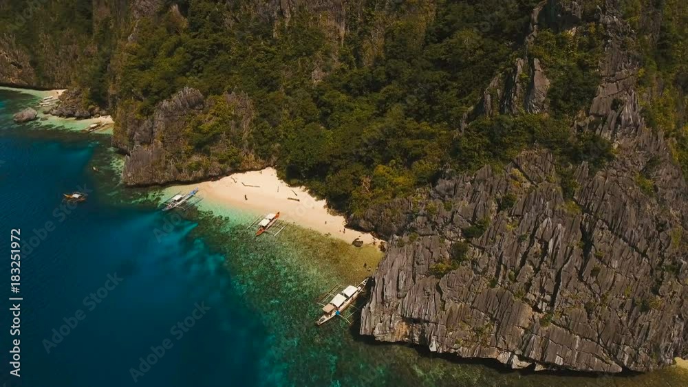 Tropical lagoon with turquoise water and white sand. Blue Lagoon with tourists and motor boats. Beautiful beach. Tropical bay in El Nido. Aerial view: bay and the tropical island. Aerial video Tropical lagoon with turquoise water and white sand. Blue Lagoon with tourists and motor boats. Beautiful beach. Tropical bay in El Nido. Aerial view: bay and the tropical island. Aerial video