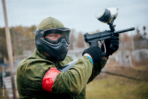Man with gun playing at paintball. Outdoors