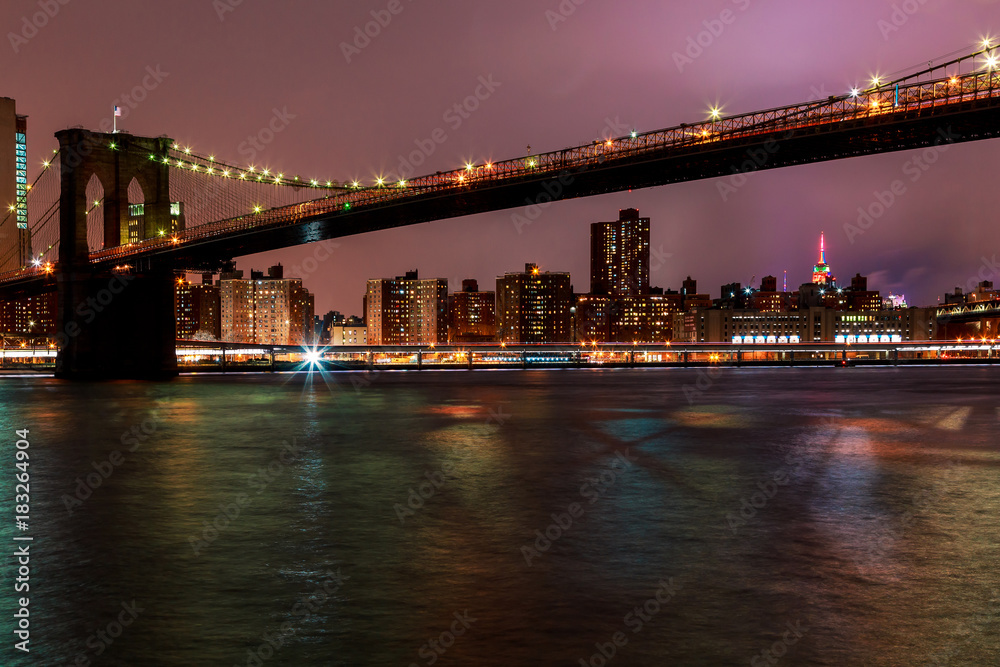 Fototapeta premium Brooklyn Bridge o zmierzchu oglądany z Brooklyn Bridge Park w Nowym Jorku.