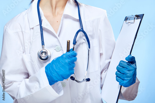 woman doctor, doctor's gown, folder, stethoscope, latex gloves, pen, close-up