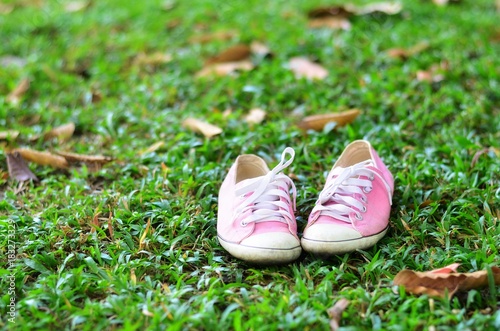 Pink sneakers on grass,Sports equipment on green grass background. 