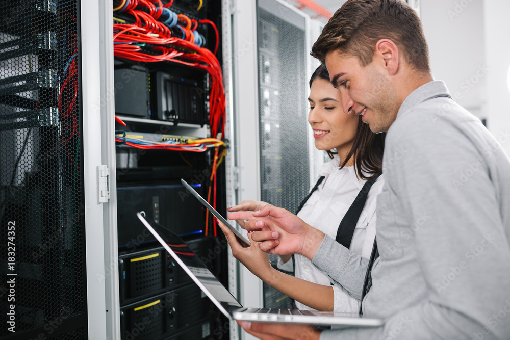 Fototapeta premium Team of technicians working together on servers at the data centre