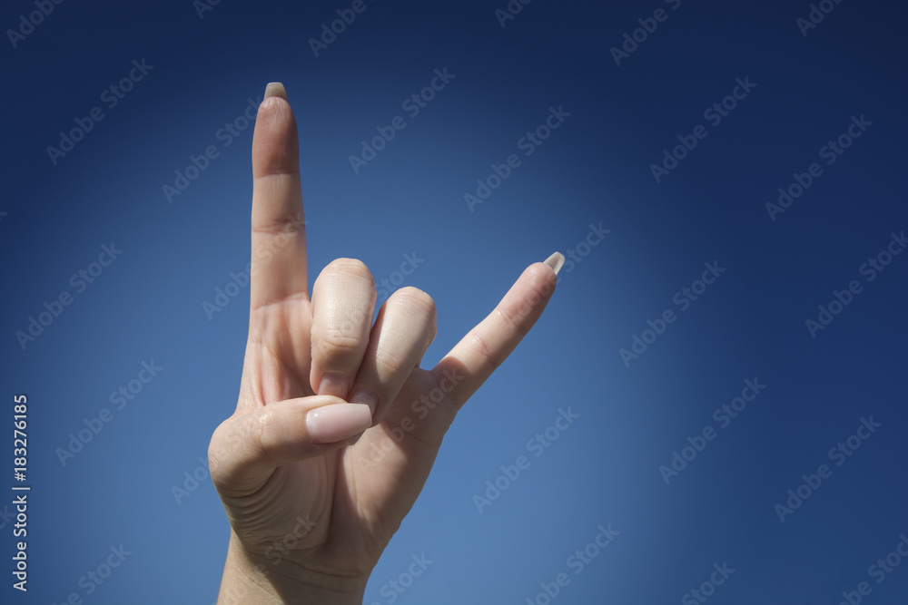 Love you sign on blue sky background, hand language Love you sign on blue sky background, hand language