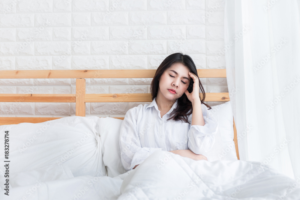 Beautiful headache woman waking up in her bed in the bedroom. Beautiful headache woman waking up in her bed in the bedroom.