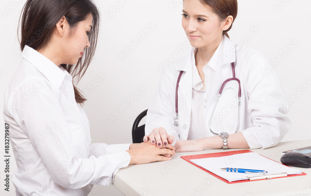 Hand of doctor reassuring her female patient in the consulting room. Hand of doctor reassuring her female patient in the consulting room.