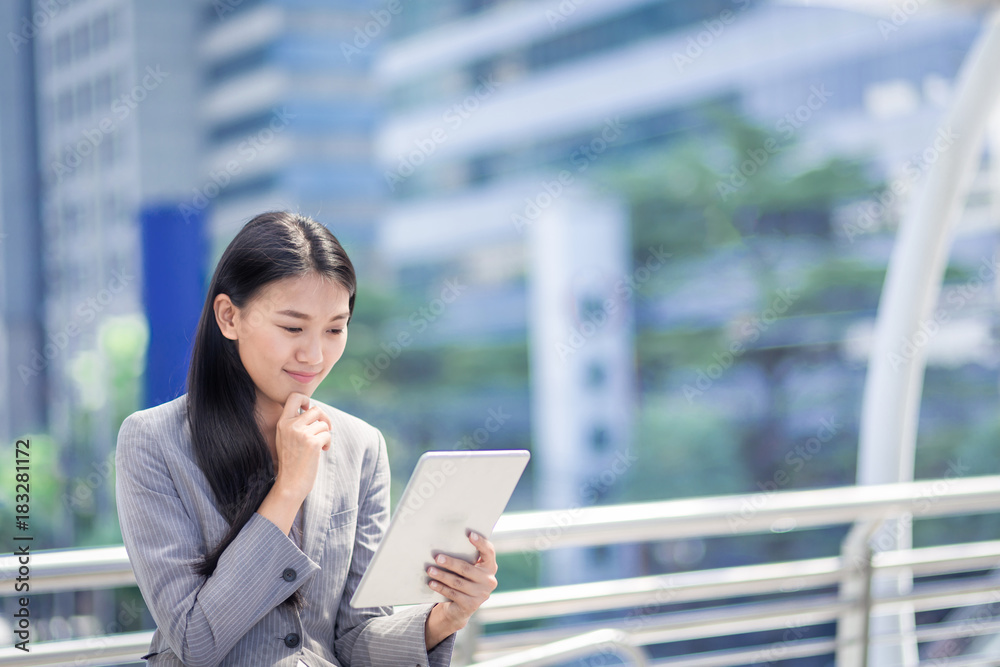 businesswoman look at his tablet in outdoor of office. businesswoman look at his tablet in outdoor of office.