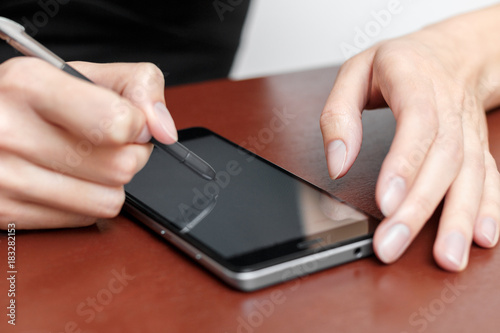 The girl behind the Desk with a smartphone and stylus.